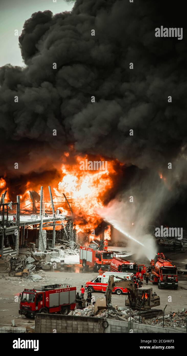 Big Fire e Dark Smoke nel porto di Beirut un mese After the Blast | vigili del fuoco e squadre di soccorso che lavorano a. Spegnere le fiamme nel porto di Beirut Foto Stock