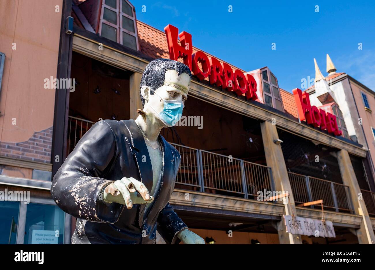 Il modello del mostro di Frankenstein che indossa una maschera COVID-19 del coronavirus a. L'Horror Hotel si trova sul Brighton Palace Pier UK Foto Stock