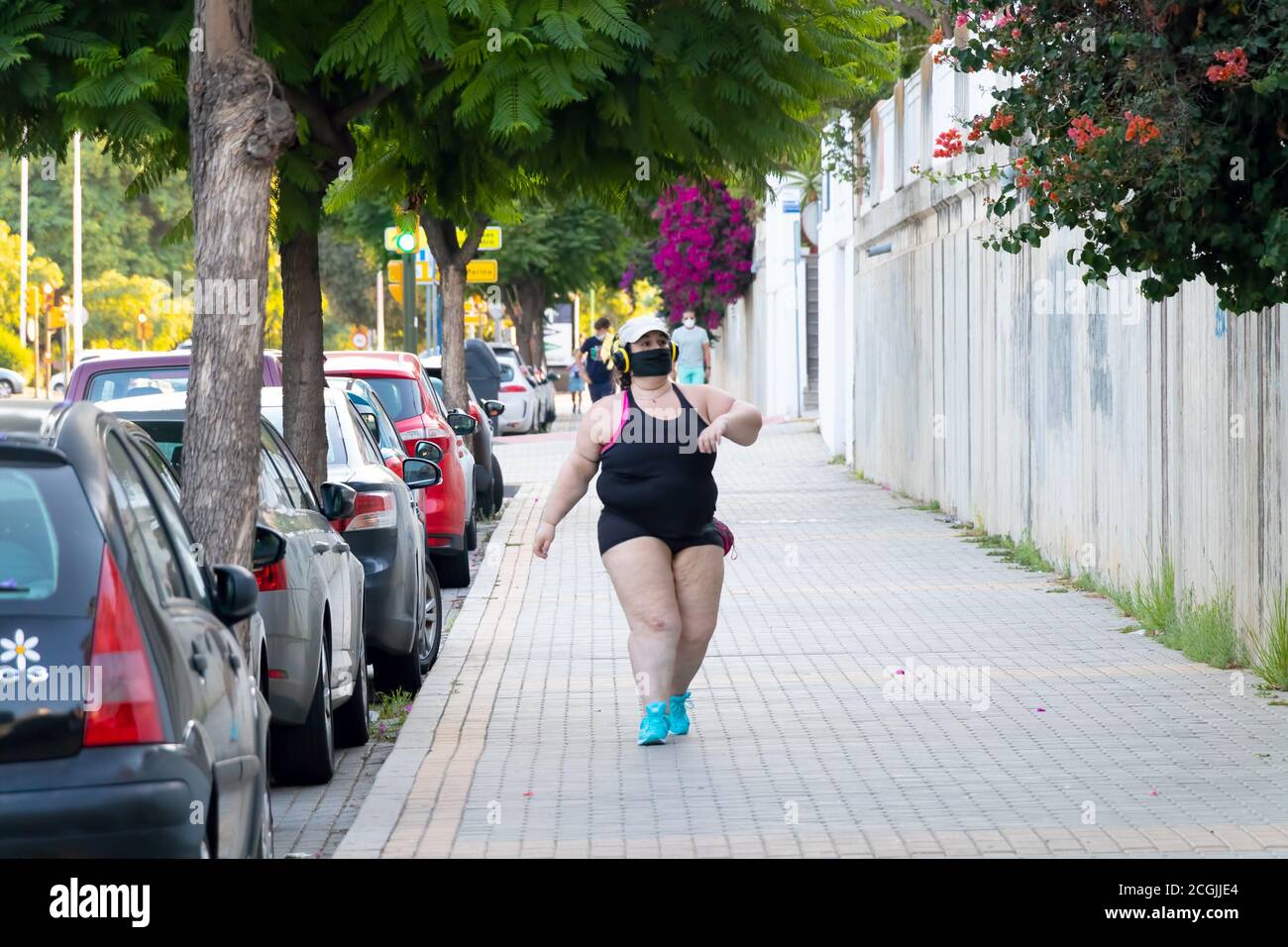 Huelva, Spagna - 10 settembre 2020: Giovane donna caucasica in sovrappeso che cammina indossando una maschera protettiva per il viso a causa del coronavirus covid-19 Foto Stock