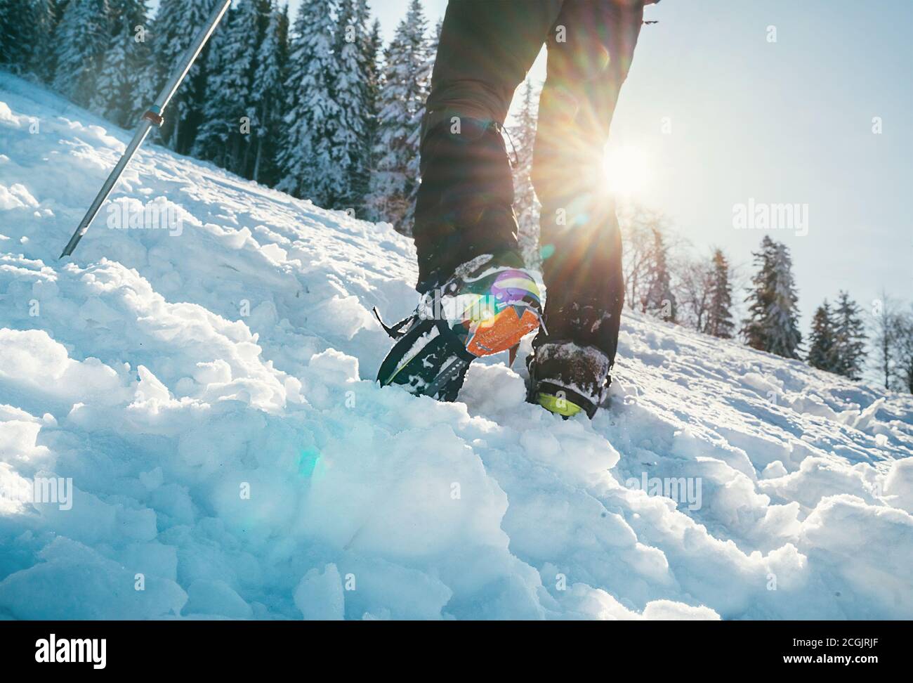 Primo piano di scarponi da montagna con ramponi e ghette da neve