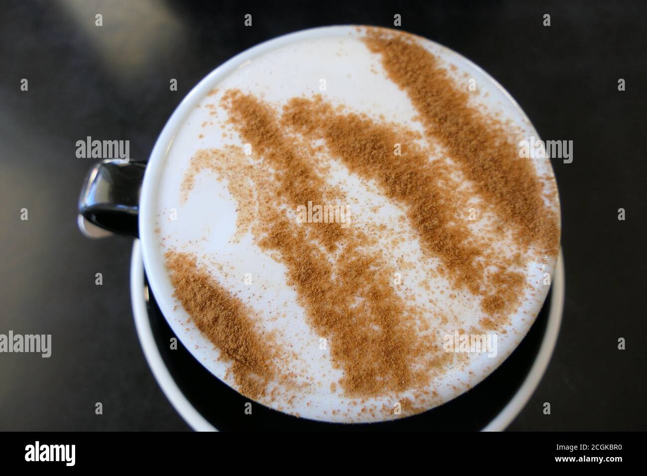Delizioso latte di chai preparato con cannella sulla parte superiore Foto Stock