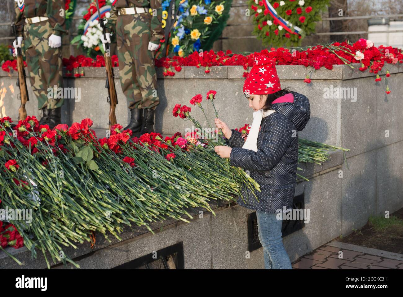 La ragazza depone fiori rossi di garofano sul Victory Memorial Durante la celebrazione della Giornata della Vittoria Foto Stock