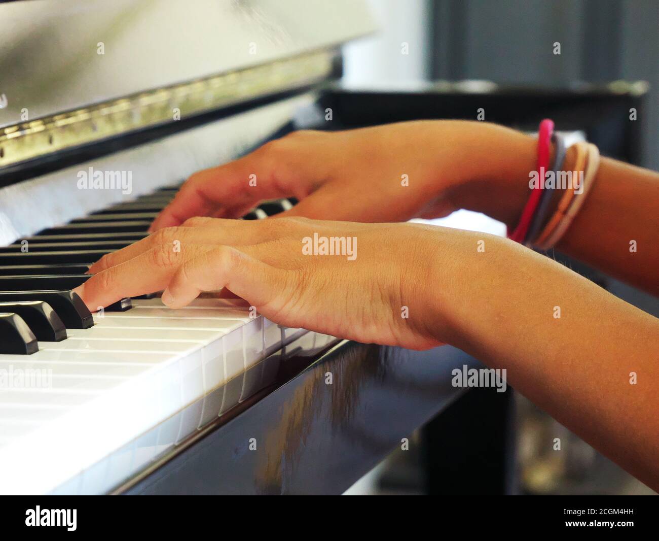 Primo piano delle mani di una ragazza che suona il pianoforte Foto Stock