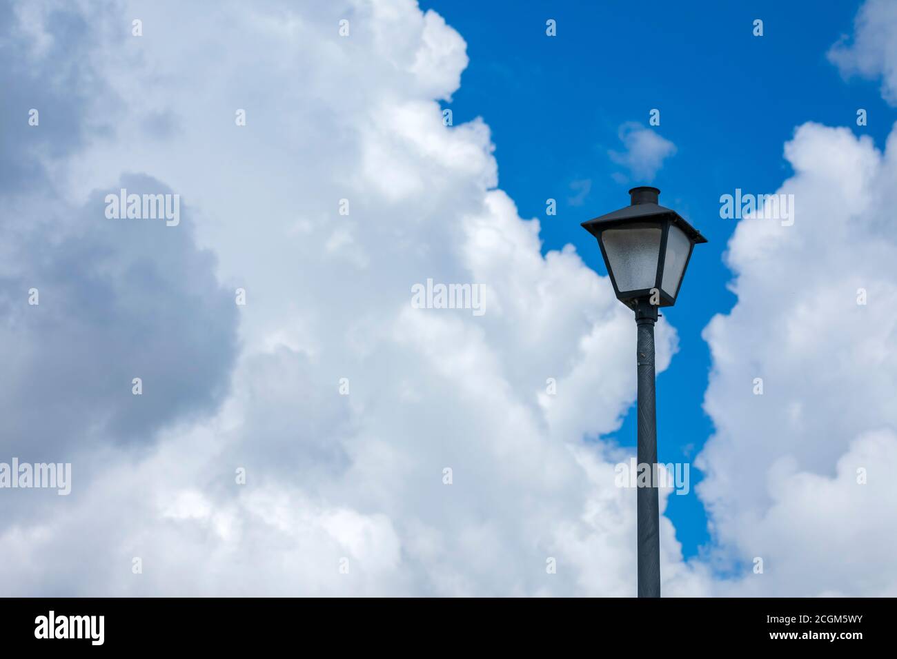 Scatto orizzontale di un lampione contro un cielo blu nuvoloso. Foto Stock