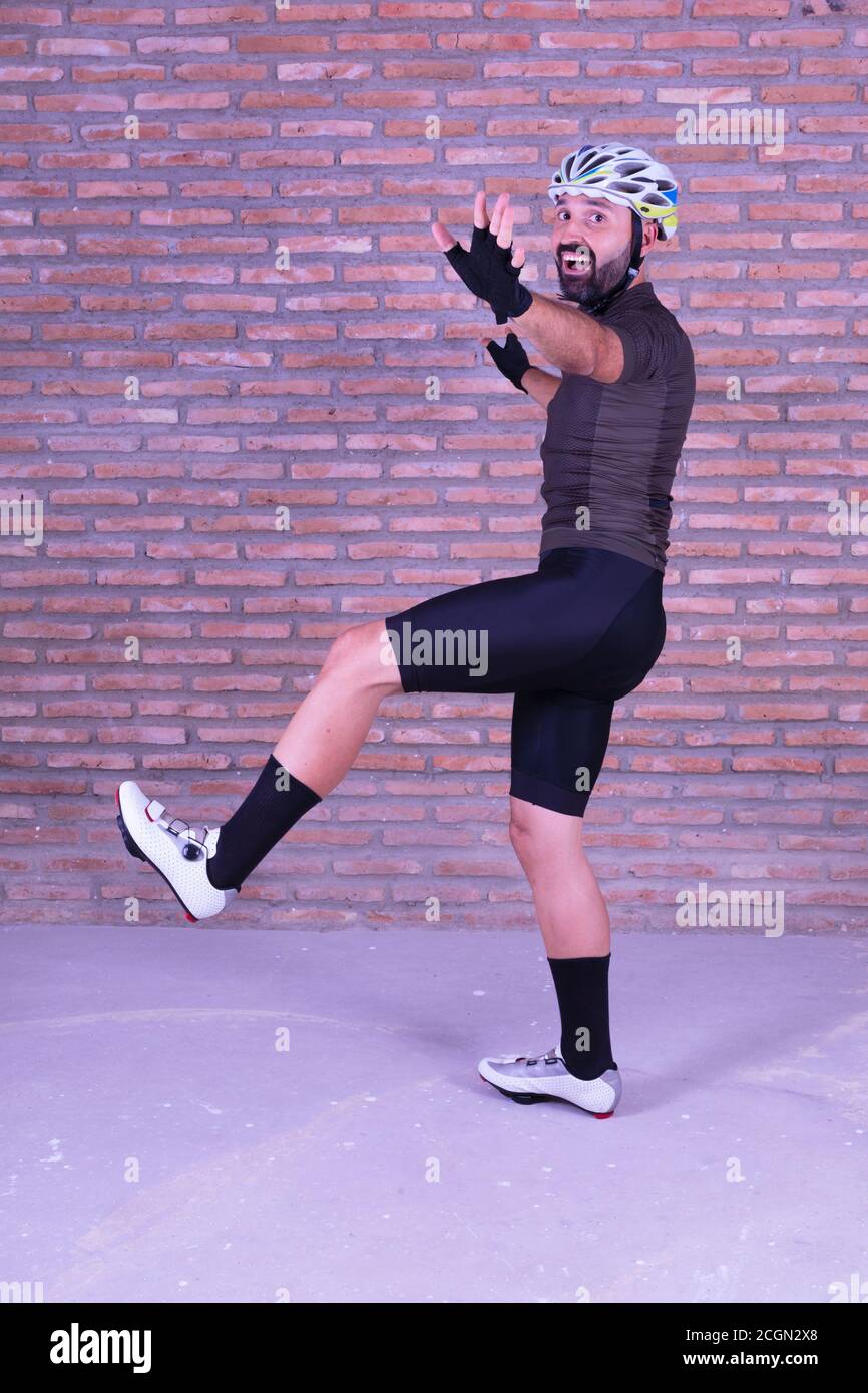 Felice giovane ciclista maschile saltando e scherzando gioiosamente Foto Stock