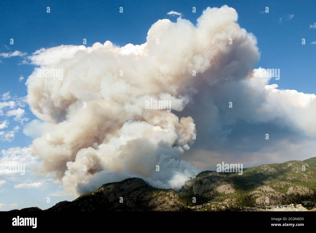 Fumo da fuoco selvatico appena iniziato che arriva nei cieli blu, Okanagan Valley, B.C., Canada Foto Stock