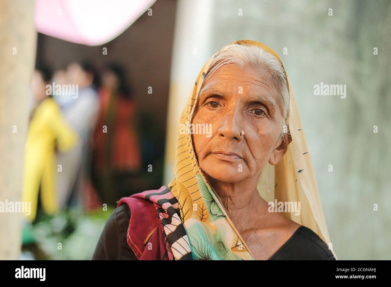 Ahemdabad, Gujarat, India - 20 giugno, 2019: Vecchia donna del villaggio indiano che indossa il saree guarda la macchina fotografica senza espressioni sul suo volto. Foto Stock