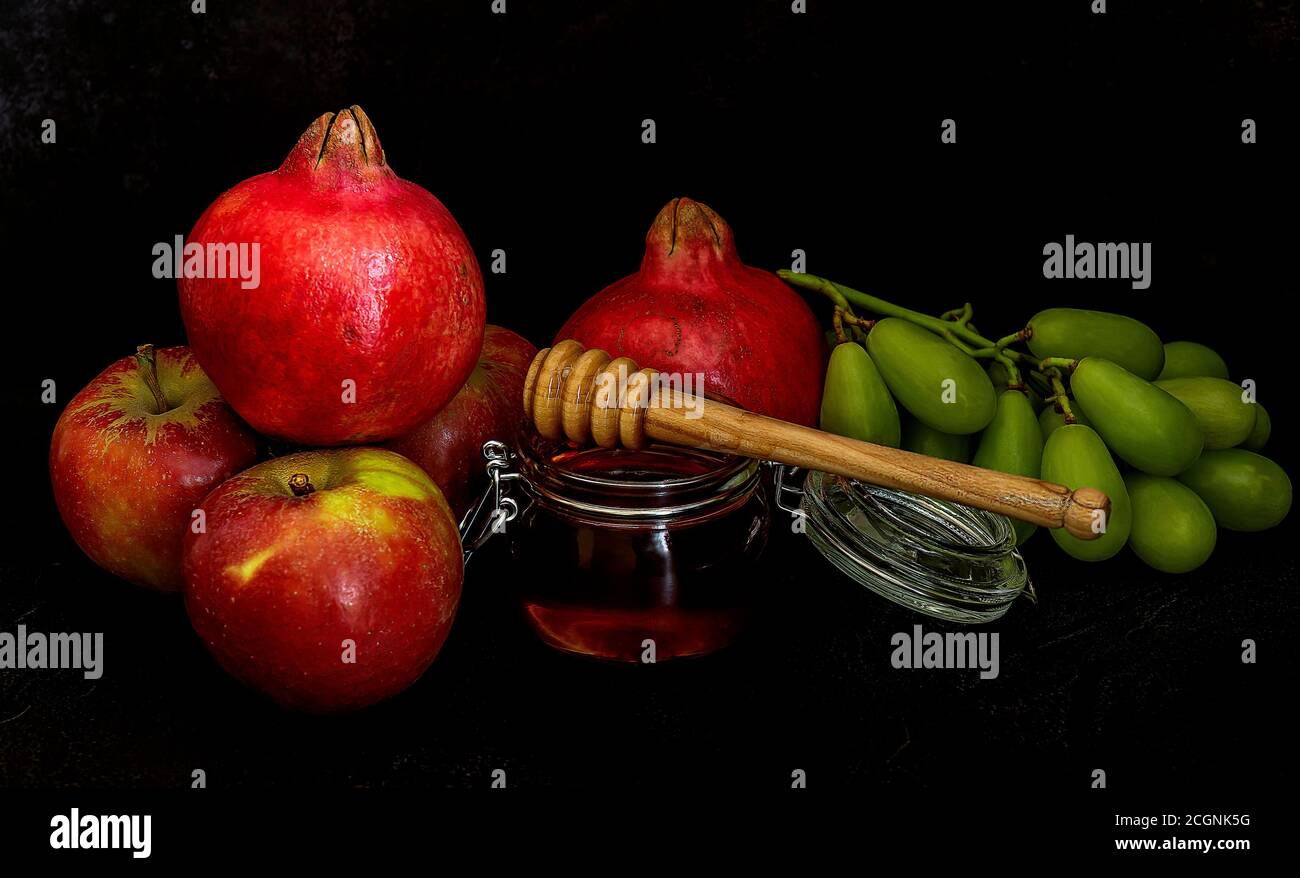 Miele, melograno e mele sulla tavola nera. Cartolina di Capodanno ebraico Rosh Hashanah. Foto Stock