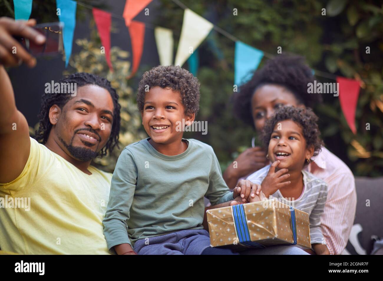 giovane padre afro-americano che prende selfie con la sua famiglia su di lui telefono cellulare Foto Stock