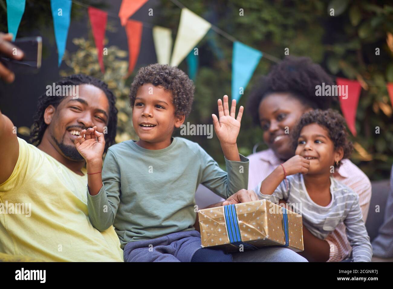 giovane padre afro-americano che prende selfie con la sua famiglia, ragazzino con le mani in su Foto Stock