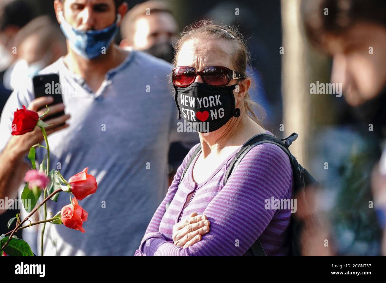 Una donna che indossa una maschera scritta su New York strong visto durante il servizio commemorativo del 9/11 al National September 11 Memorial and Museum. La cerimonia per ricordare coloro che sono stati uccisi negli attacchi terroristici 19 anni fa sarà modificata quest'anno per aderire alla sicurezza Precauzioni relative alla trasmissione COVID-19. Foto Stock