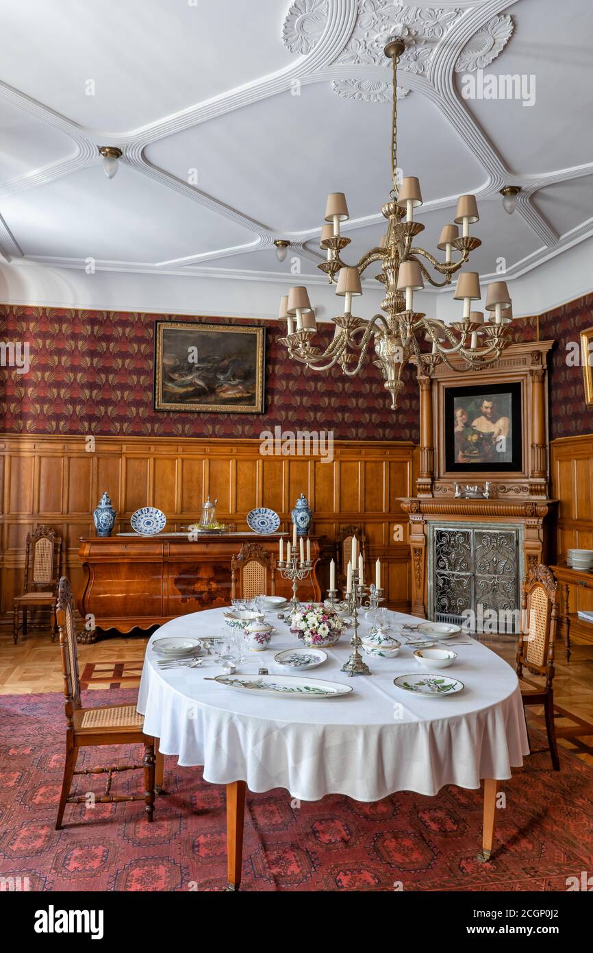 Herbst Palace Museum interni a Lodz, Polonia, sala da pranzo in residenza del 19 ° secolo, servizio al tavolo Flora Danica e pannelli di quercia Foto Stock