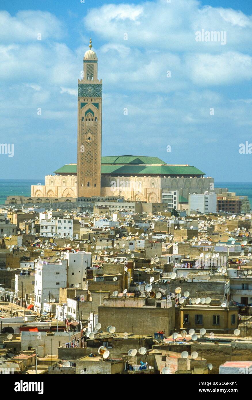 Casablanca, Marocco. I piatti satellite coprono i tetti nella Medina di Casablanca, Moschea di Hassan II in background. Fotografato aprile 2003. Foto Stock