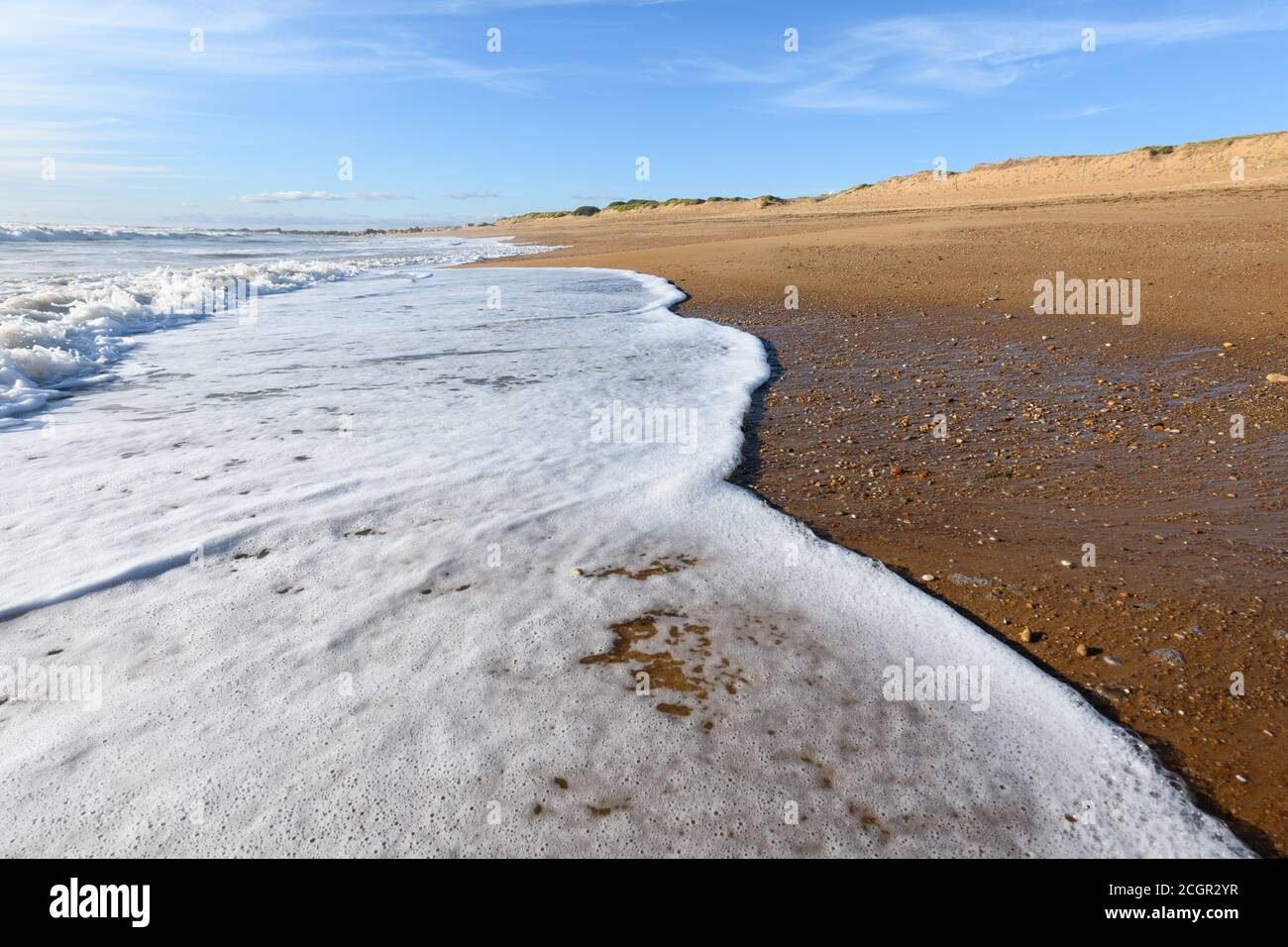Schiuma di mare sulla bellissima spiaggia di sabbia dell'oceano Atlantico in Francia. Foto Stock