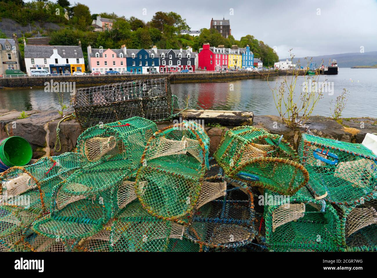 Vista delle pentole di aragosta e degli edifici colorati lungo il lungomare del porto di Tobermory su Mull, Argyll & Bute, Scozia, Regno Unito Foto Stock
