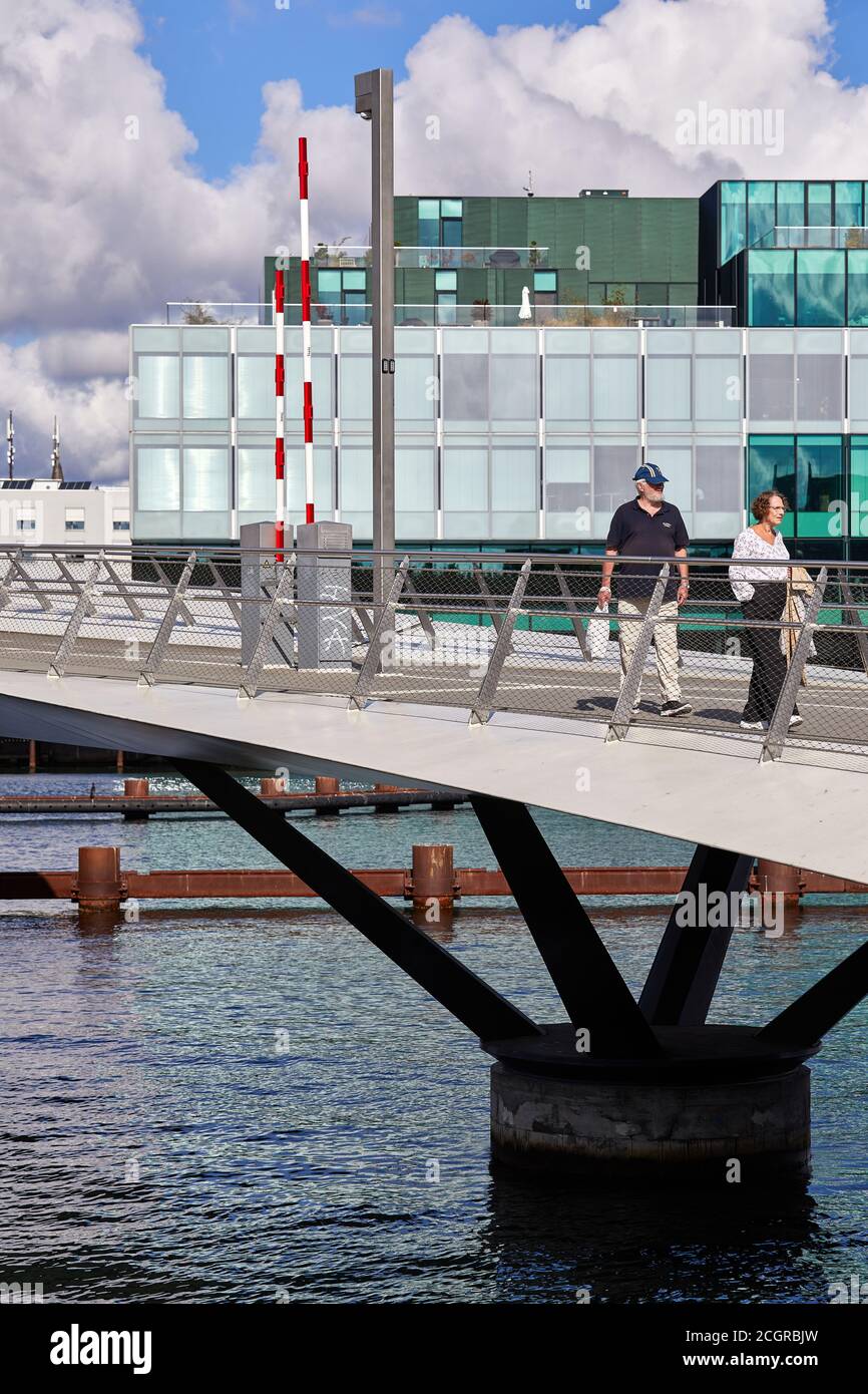 Due persone a Lille Langebro, ponte a piedi e in bicicletta attraverso il porto di Copenhagen, BLOX sullo sfondo, Copenhagen, Danimarca Foto Stock