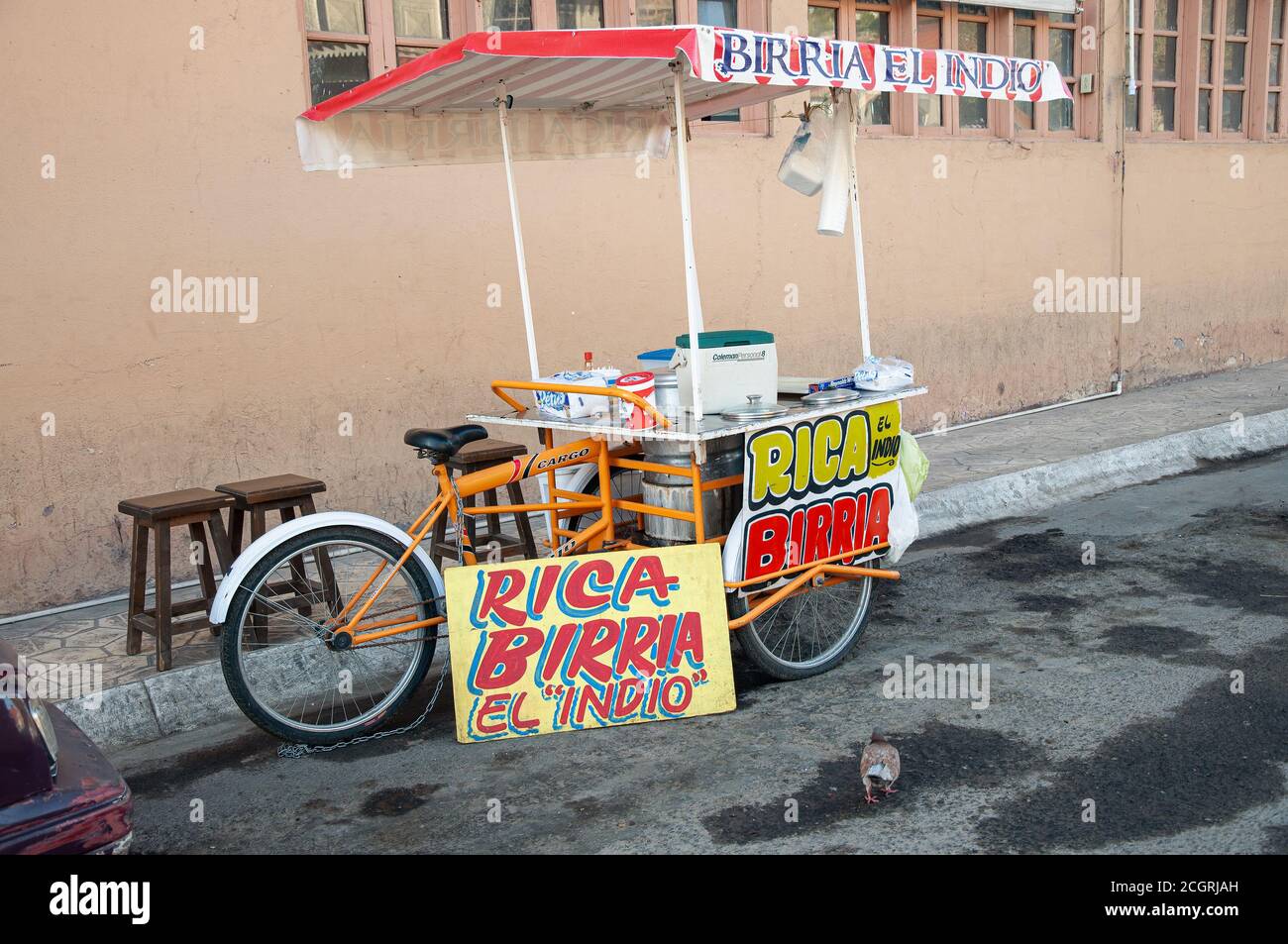 Un carrello di cibo per biciclette che vende stufato di carne parcheggiato in una strada sporca, la mattina presto e non ancora aperto per affari. Foto Stock