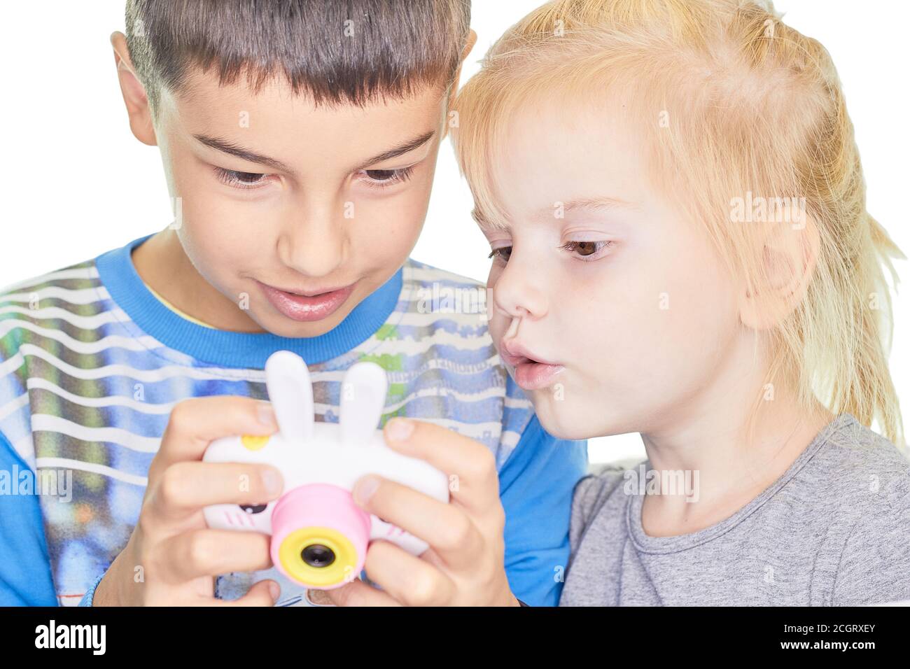 Foto di due bei bambini con una macchina fotografica un ragazzino e una ragazza che gioca un gadget . Concetto di tecnologia di formazione. Foto Stock