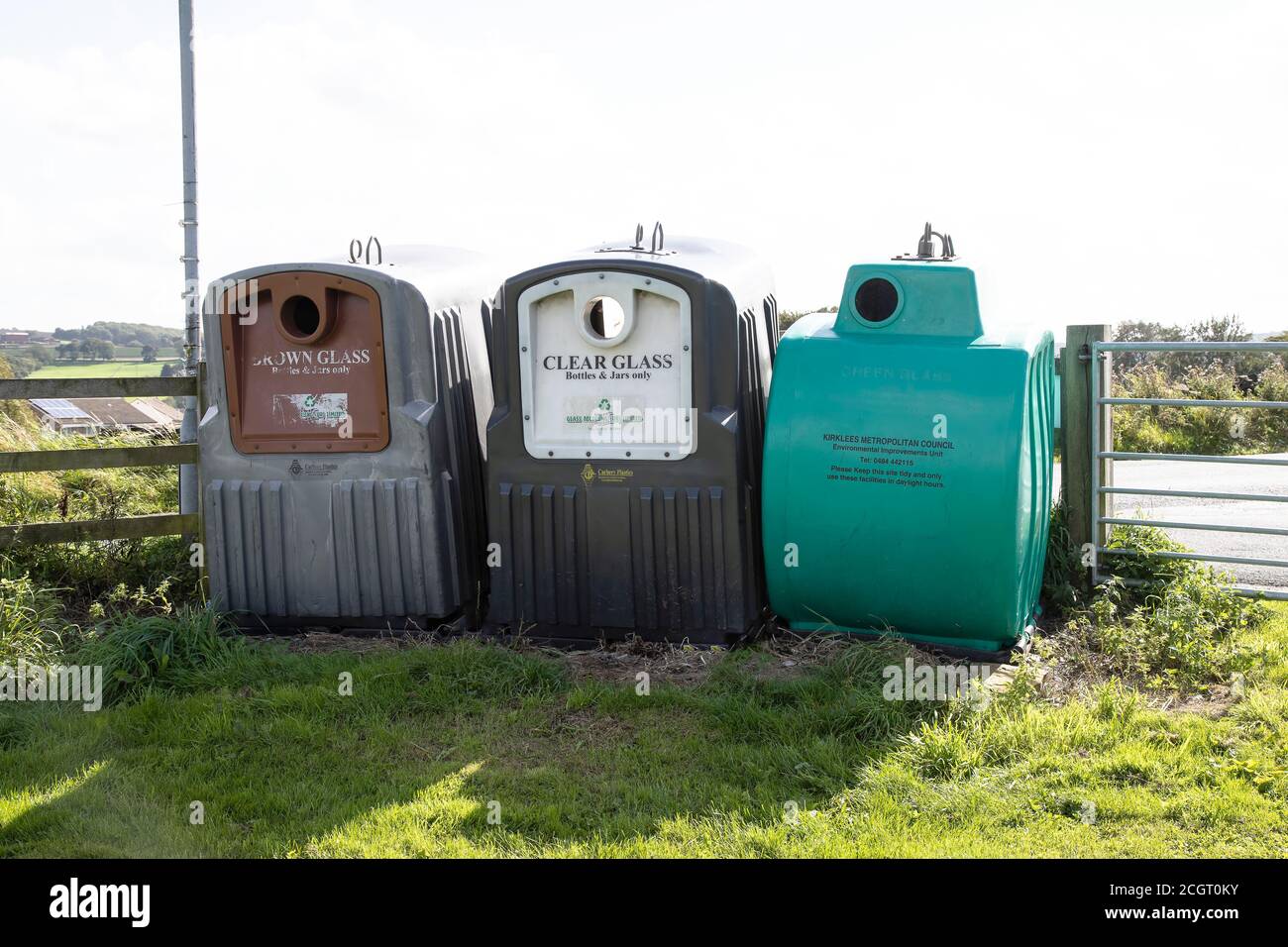 Una banca rurale di bottiglie per vetro riciclato e bottiglie, trasparente, verde e marrone situato ai margini di un parco pubblico in Huddersfield, West Yorkshire Regno Unito Foto Stock