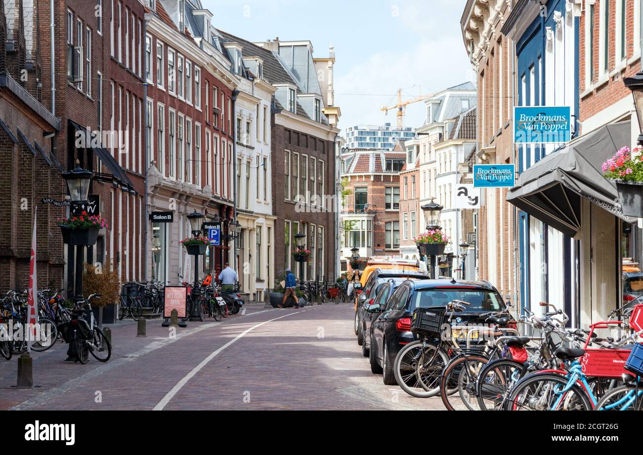 Ammira il centro storico di Utrecht. Minrebroederstraat con numerosi negozi e vecchie case in una giornata di sole. Utrecht, Paesi Bassi. Foto Stock