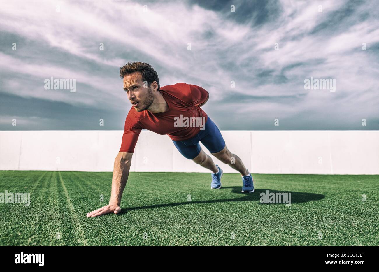 Un braccio spinta in su l'esercitazione del peso del corpo uomo forte che lavora fuori i muscoli con variazione avanzata dei push-up. Allenati in palestra Foto Stock