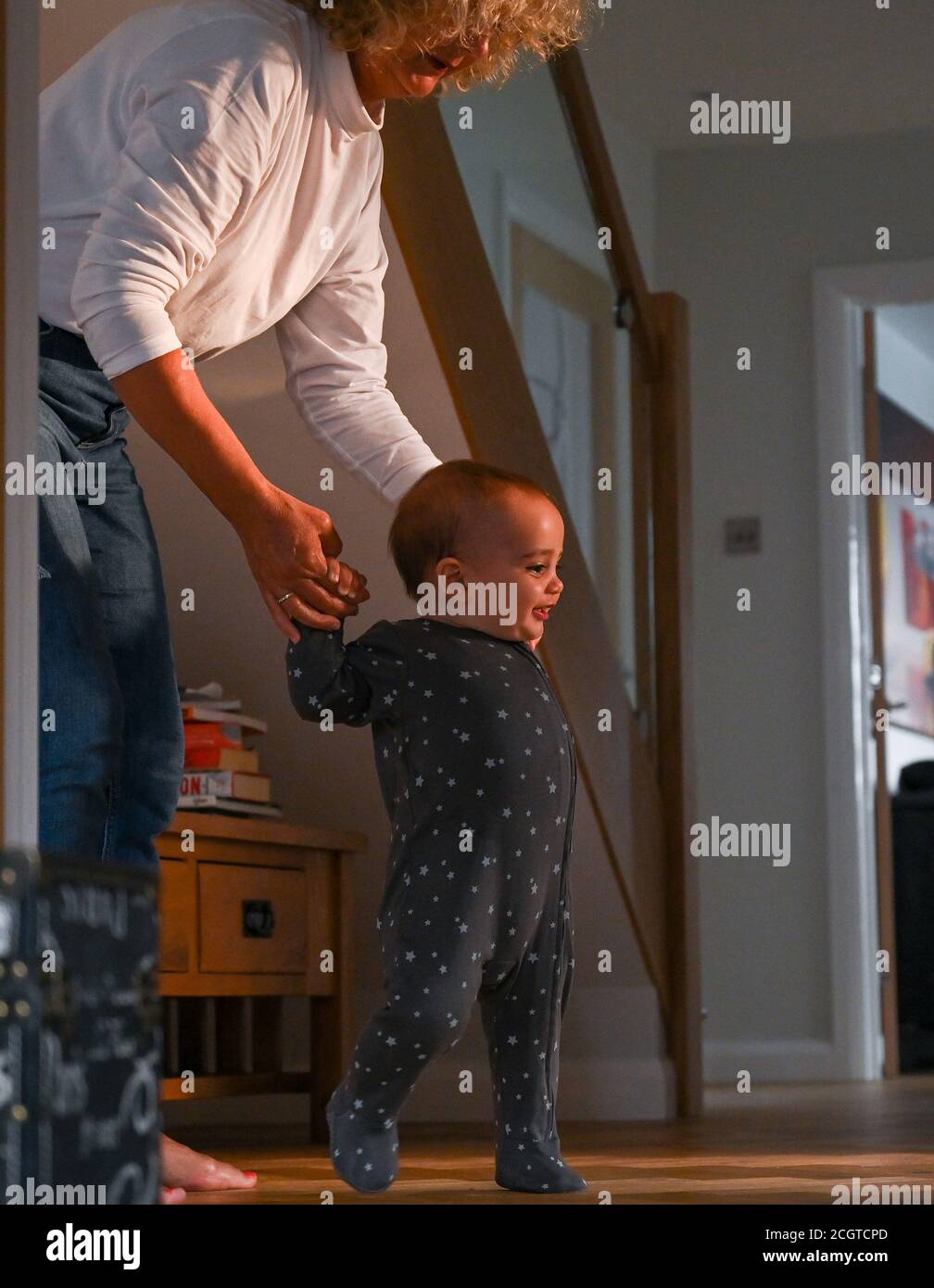 Bambino giovane di 10 mesi ragazzo imparando a camminare con sua nonna Foto Stock