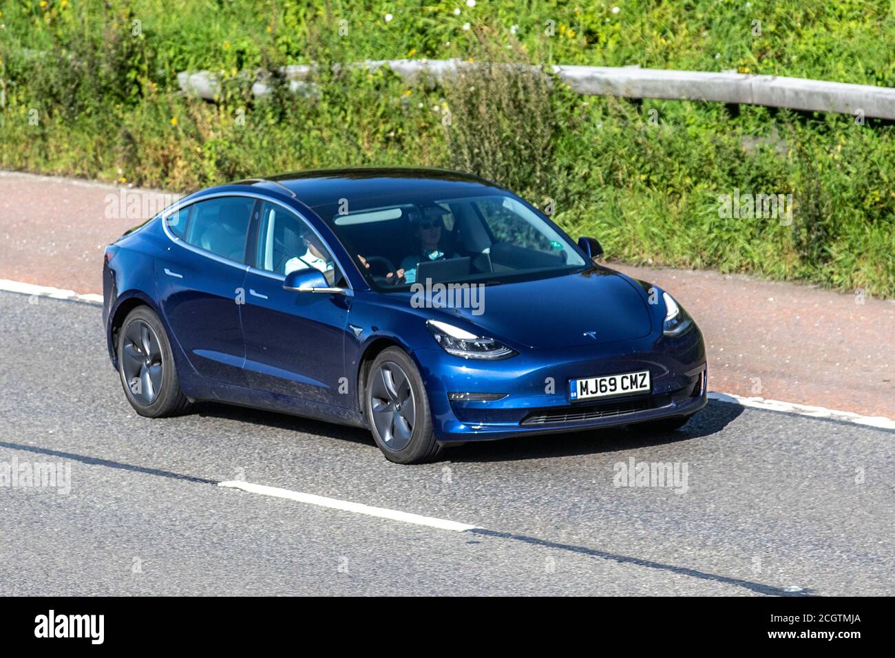 2019 blu Tesla Model EV 3 Long Range AWD; veicoli in movimento per il traffico veicolare, auto che guidano veicoli su strade del Regno Unito, motori, auto sulla rete autostradale M6. Foto Stock