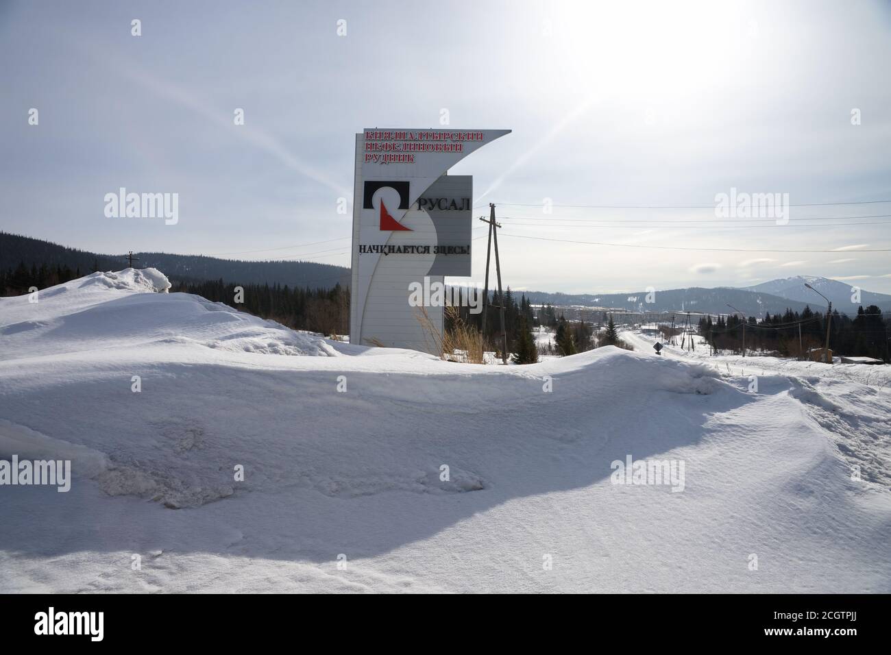 Stele con il logo della società 'RUSAL' si trova sulla deriva di neve sullo sfondo della taiga. Foto Stock