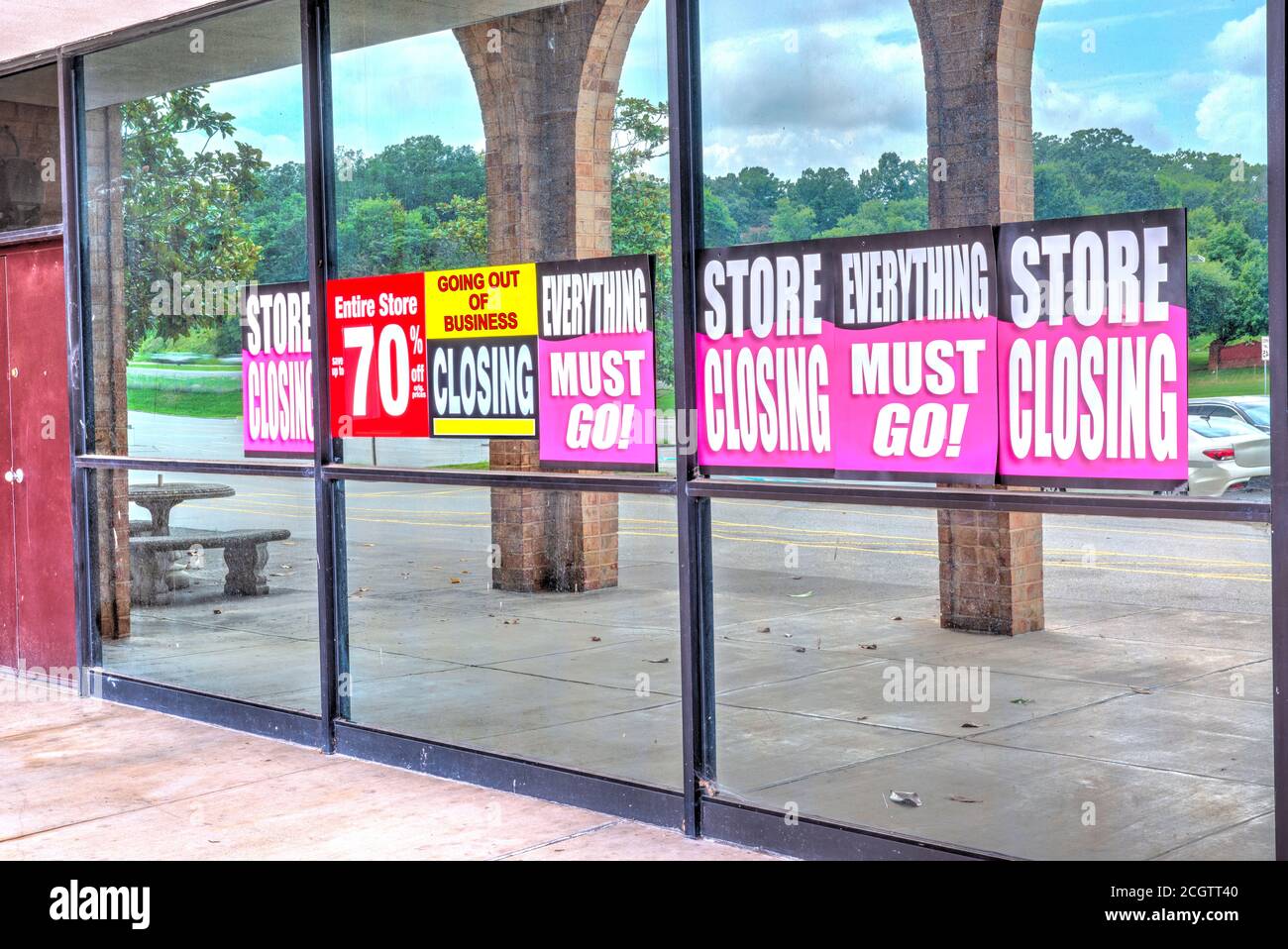 Immagine orizzontale delle finestre di un negozio al dettaglio con uscendo dai segni di affari pubblicati su loro dopo il pandemia Foto Stock