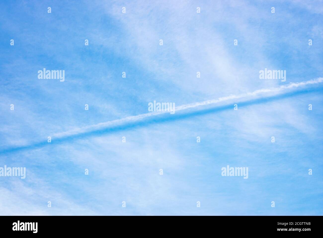 Il contrasto del vapore acqueo emesso da un aeromobile getta un ombra sul livello cloud sottostante Foto Stock