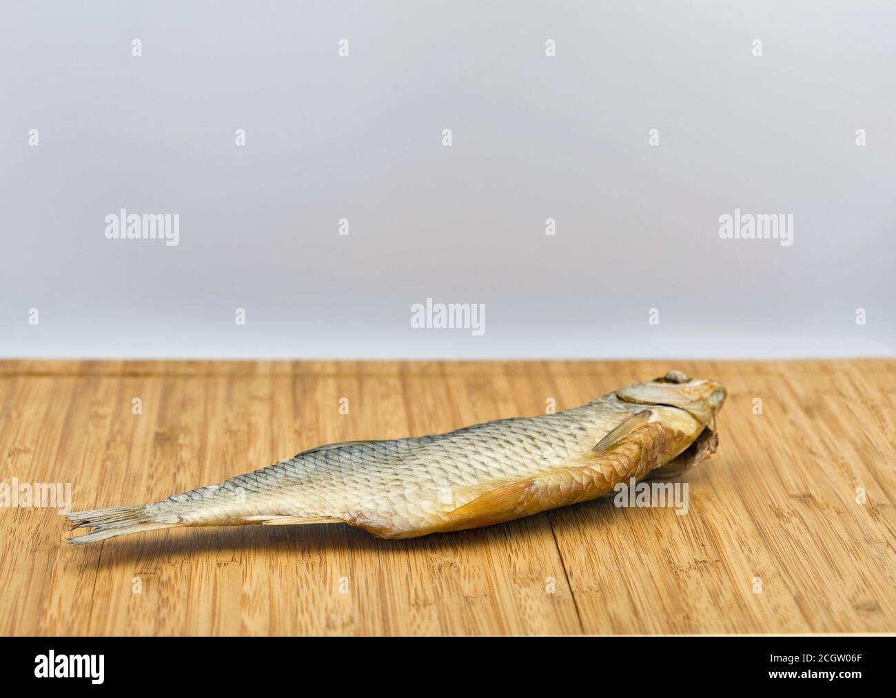 un pesce secco di ariete su uno sfondo rustico di legno closeup contro il bianco Foto Stock