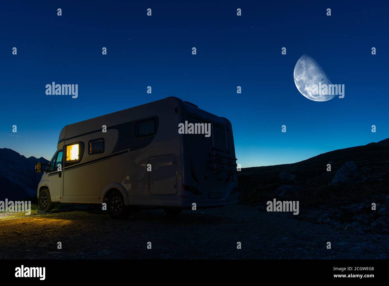 Moderno veicolo ricreativo RV Camper Van e Clear Night Starry Sky con Luna sopra Camping Pitch. Tema RV. Foto Stock