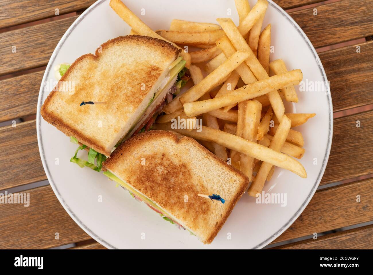 Club sandwich e patatine fritte su un piatto per un pasto delizioso quando affamato. Foto Stock