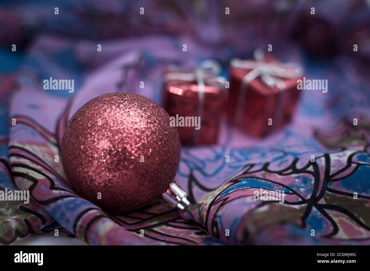 Natale decorazione palle e regali su sfondo tessile di viola colori Foto Stock