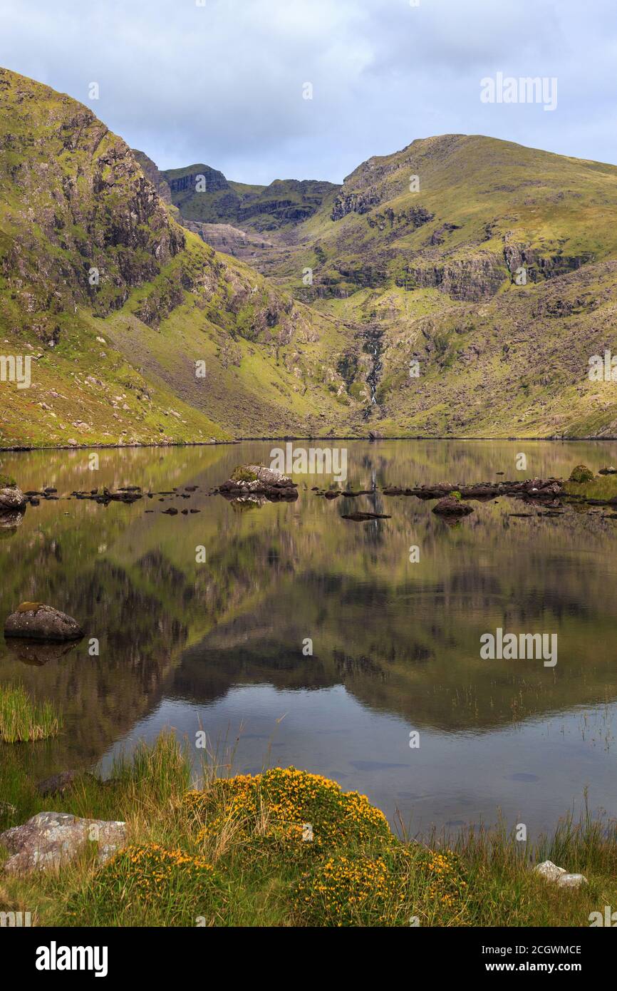 Guardando verso nord-ovest lungo una tranquilla Loch Cruite verso la Corrie orientale sotto Brandon Mountain sulla penisola di Dingle nella contea di Kerry, Irlanda Foto Stock