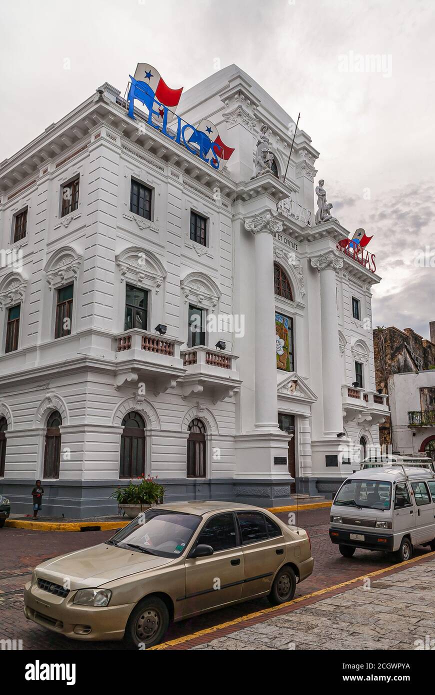 Città di Panama, Panama - 30 novembre 2008: Il vecchio municipio è un edificio storico bianco con bandiere e statue in cima sotto il paesaggio nuvoloso grigio. Le auto nel Foto Stock