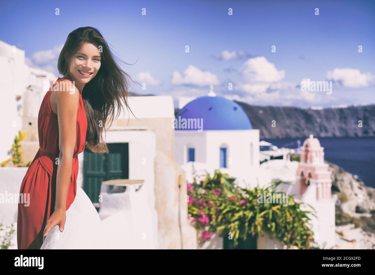Europa Grecia Santorini viaggio di lusso vacanza donna sulla famosa isola di santorini Oia viaggio destinazione europea. Abito rosso elegante donna su jet set Foto Stock