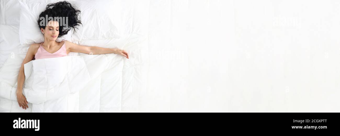 Giovane bellezza caucasica donna che dorme sul letto bianco Foto Stock