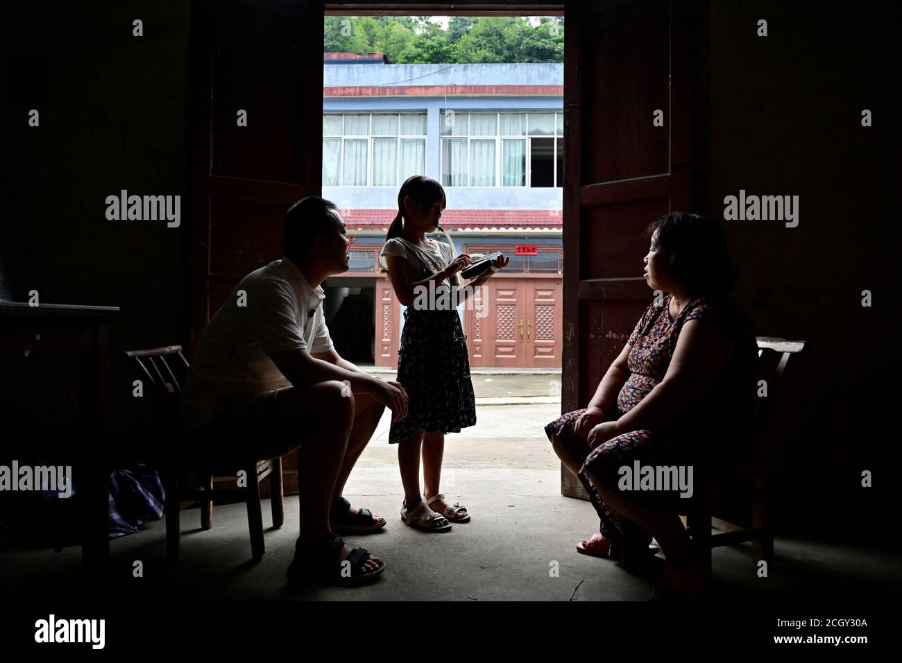 Nanchang, provincia cinese di Jiangxi. 4 Settembre 2020. Li Jiating (C), membro della band melodica della Yantian Primary School, suona una nuova melodia per sua madre, mentre l'istruttore della band Yang Hao (L) paga una visita a casa nella contea di Wanzai, nella provincia di Jiangxi nella Cina orientale, il 4 settembre 2020. PER ANDARE CON 'Xinhua titoli: Melodica apre la porta del mondo della musica per i bambini rurali' Credit: Peng Zhaozhi/Xinhua/Alamy Live News Foto Stock