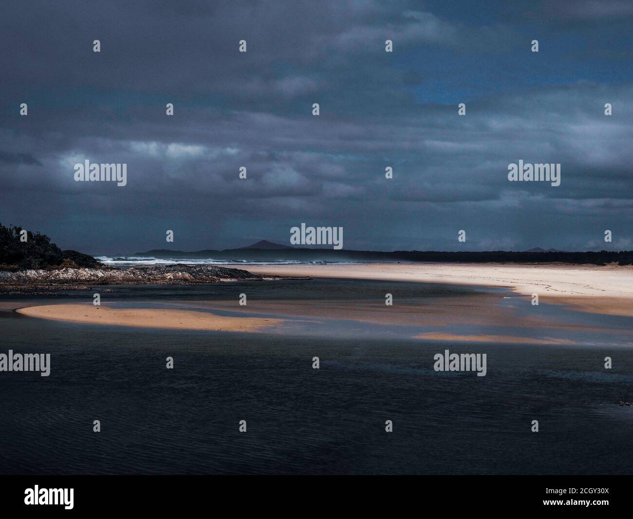 Ombre e sole. Fotografia artistica di una scena balneare in un giorno tempestoso sulla costa orientale australiana Foto Stock