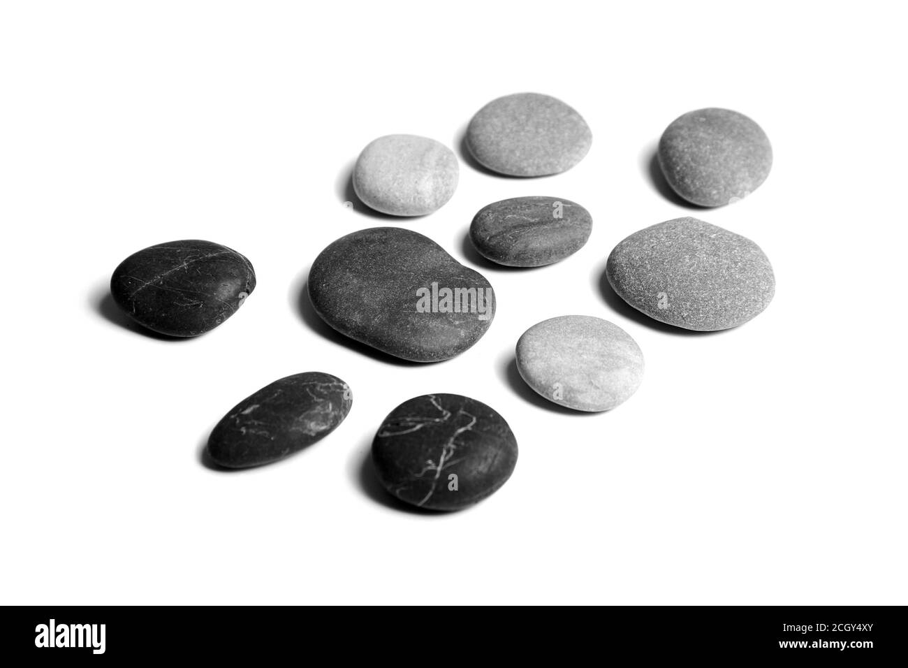 Ciottoli, di colore nero e grigio pietre di mare lisce isolate su sfondo bianco Foto Stock