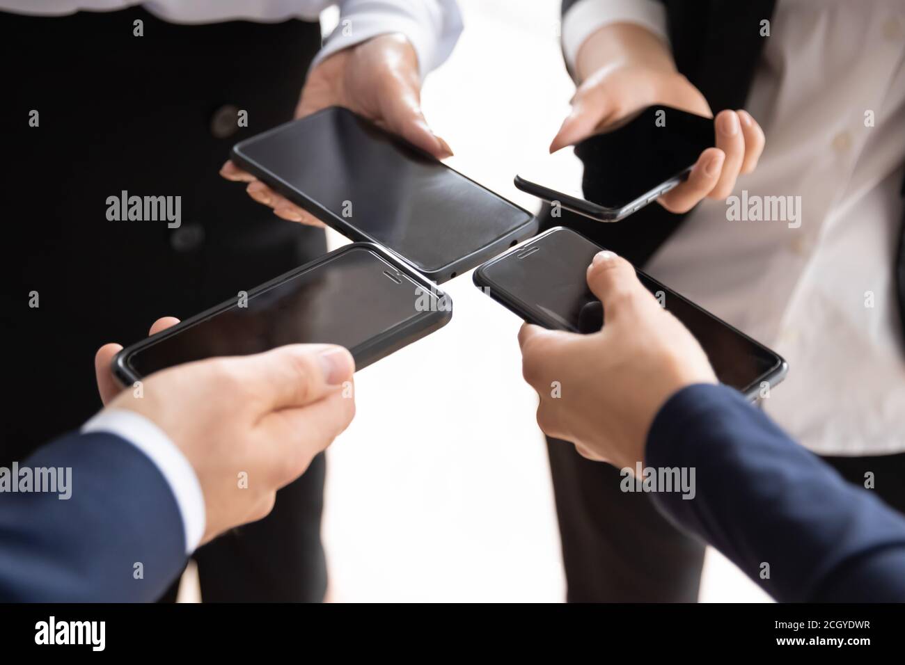 Primo piano di uomini d'affari diversi che utilizzano gli smartphone Foto Stock