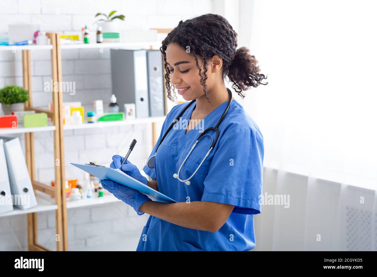 Felice medico veterinario che scrive sulla clipboard presso la clinica animale Foto Stock