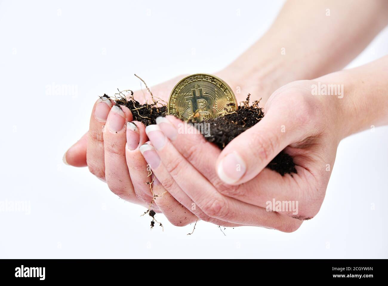 Le mani della donna tengono il suolo nero e la moneta di bitone. Estrazione a criptovaluta. Coltivatore che fa soldi Foto Stock