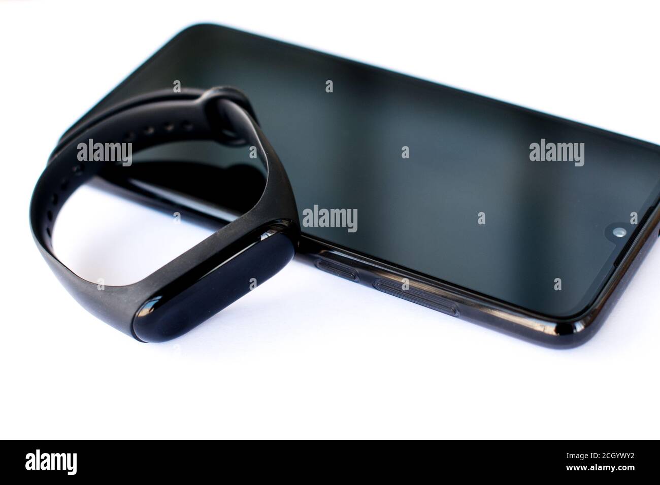 Fitness tracker e smartphone su sfondo bianco. Tecnologia mobile individuale per dispositivi sportivi Foto Stock