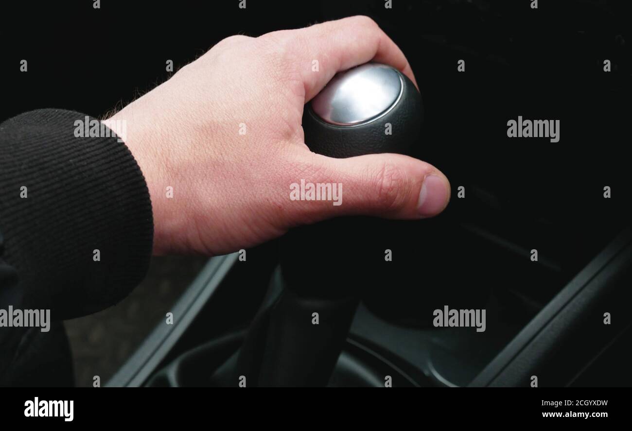 Mano sul selettore marce in auto, close-up. Automobili con guida a destra. Foto Stock