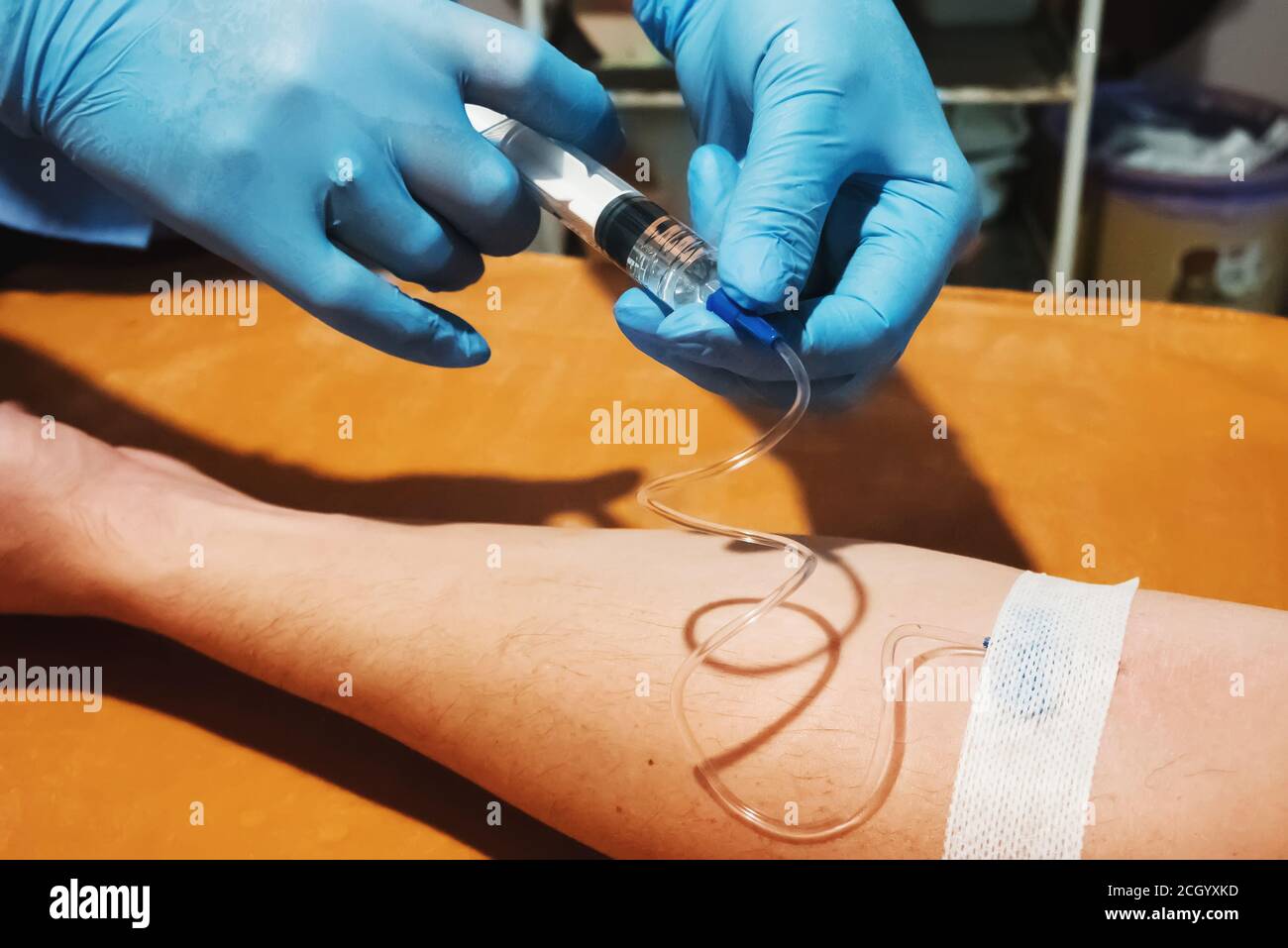 Mani del medico con una siringa per iniezione al paziente. Il medico effettua un'iniezione endovenosa al paziente. Foto Stock