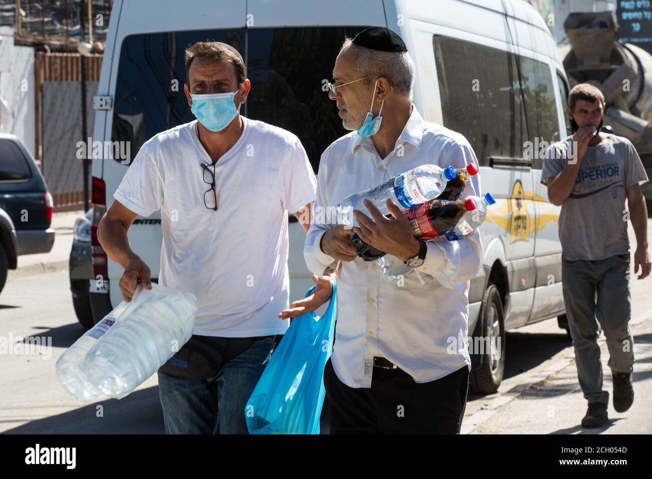 Due turisti israeliani che sono arrivati a Uman, in Ucraina, per celebrare il Capodanno ebraico Rosh-ha-Shana durante la chiusura, trasportano bottiglie di acqua rifornita in calore Foto Stock
