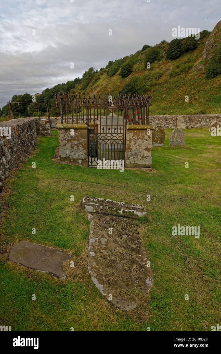 Una tomba caduta e mezza sepolta di fronte a un recinto di sepoltura presso il cantiere di Nether kirk, ai piedi delle scogliere di St Cyrus. Foto Stock