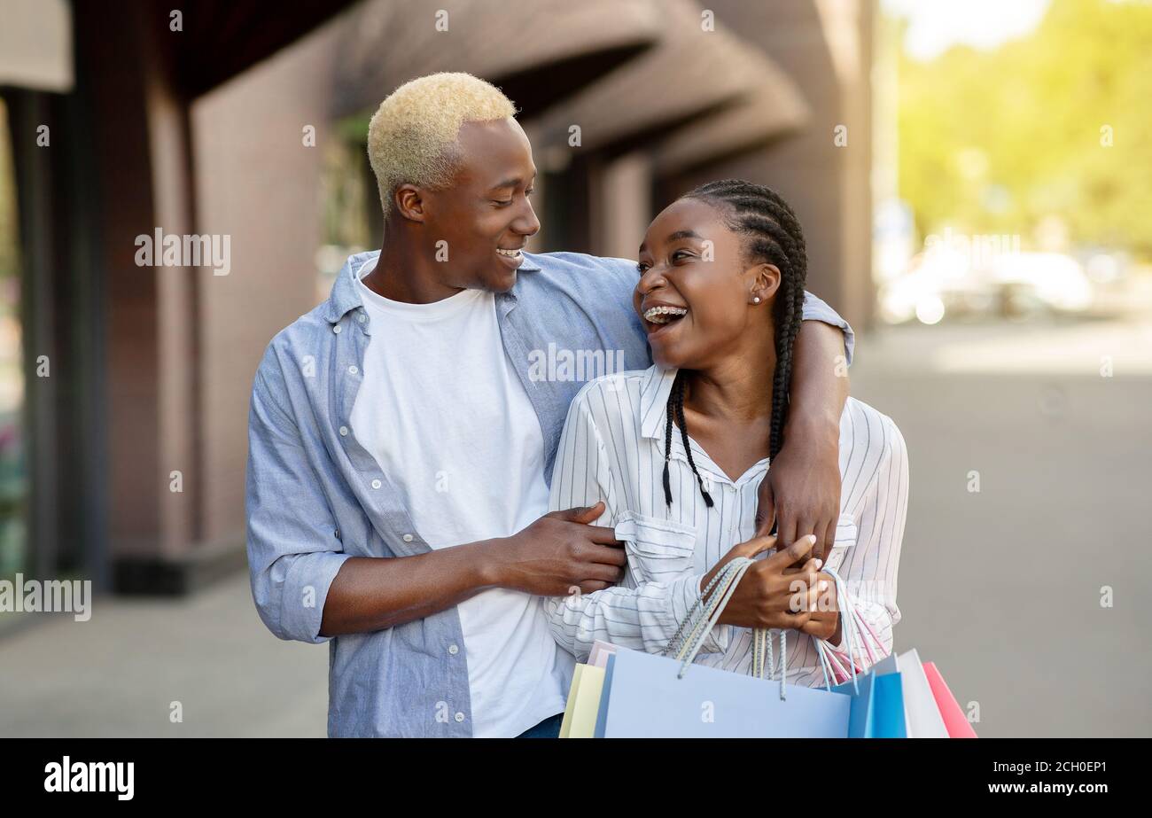 Tempo libero, divertimento e shopping. Sorridente abbraccio di coppia afroamericana Foto Stock